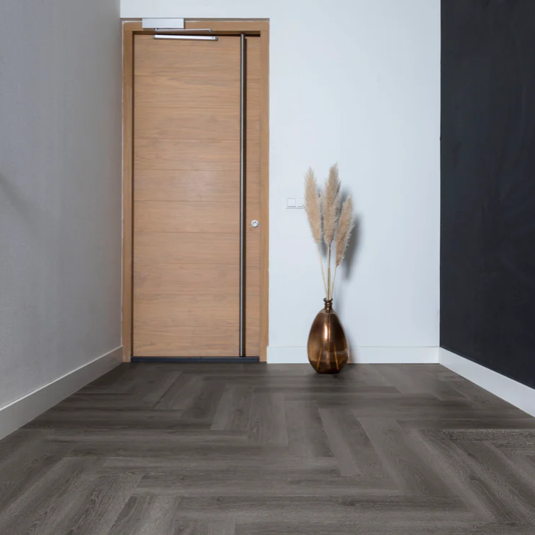 Een gang met een rustige uitstraling dankzij Hebeta Progress Visgraat XL - Warm donker bruin - 15,3 cm x 76,5 cm vloer in grijs eiken.