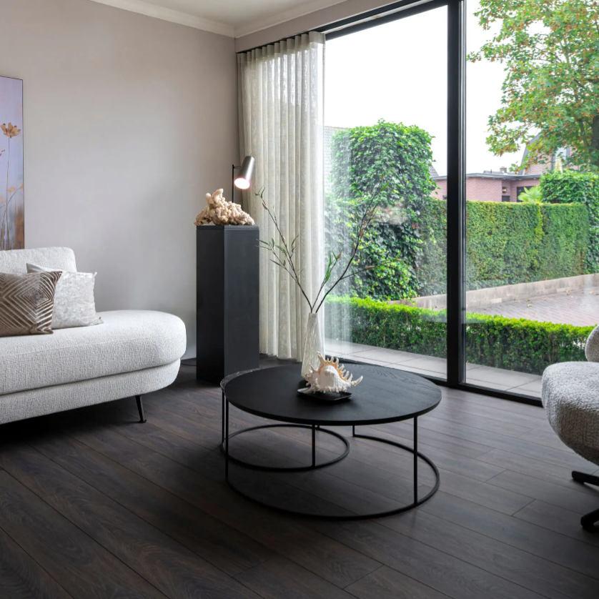 Woonkamer met een rustige uitstraling dankzij Hebeta laminaat - Organic eiken donker gerookt- klik vloer in donker eiken.