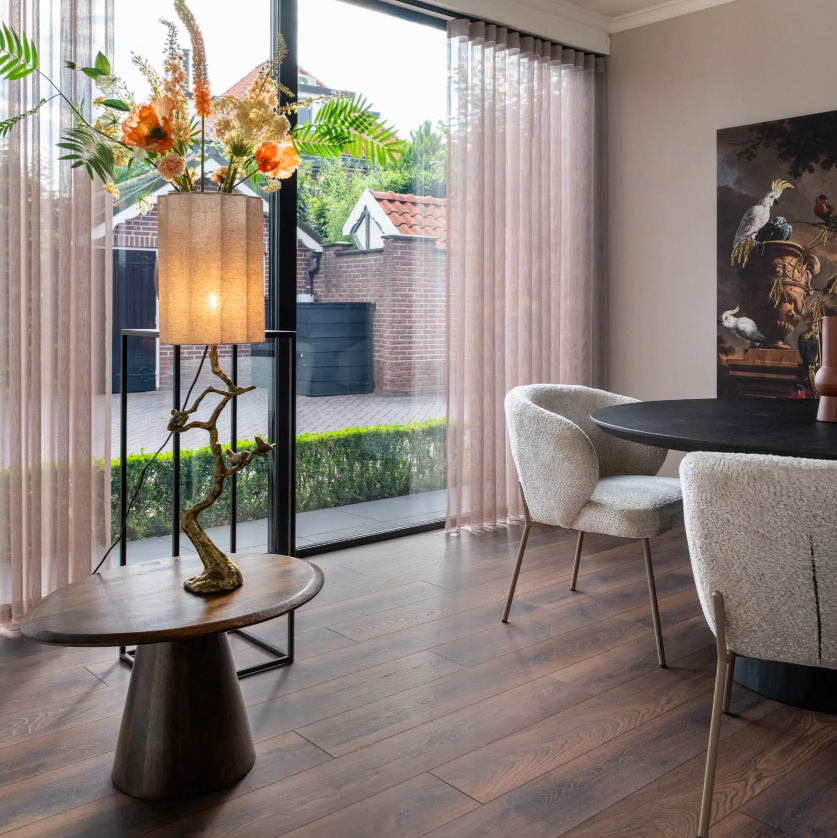 Woonkamer met een tijdloze uitstraling dankzij de Hebeta laminaat - Organic kastanje - klik vloer in bruin eiken.