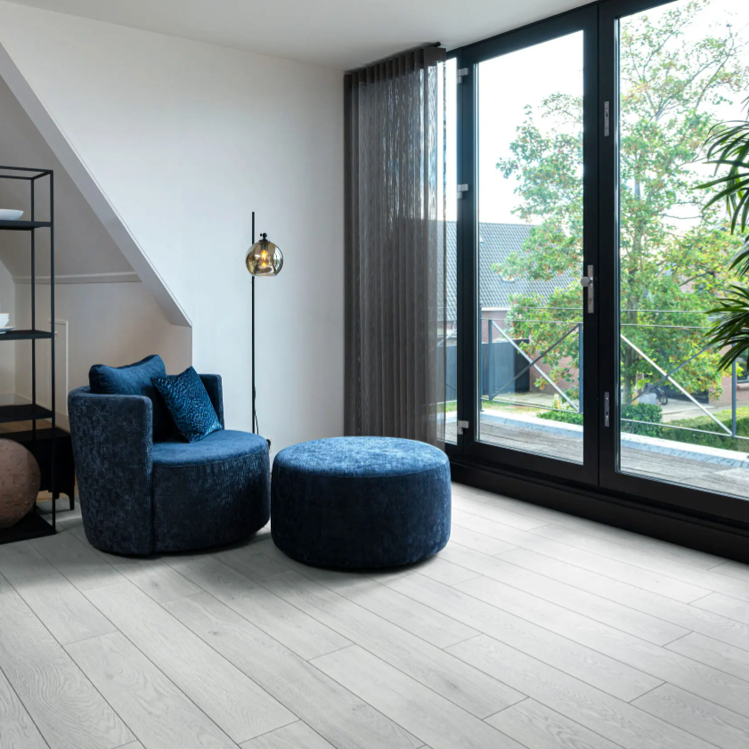 Woonkamer met een rustige uitstraling dankzij Hebeta laminaat - Organic licht gerookt eiken- klik vloer in grijs.